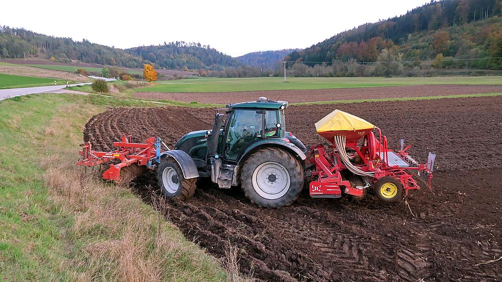 Ein Bauer mit dem Traktor auf dem Feld.