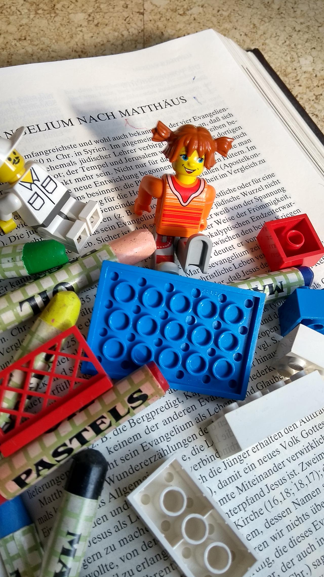 Legobausteine und Figuren auf einem Buch.