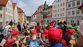 Teilnehmende der Kinderwallfahrt am Willibaldsbrunnen am Eichstätter Marktplatz. 